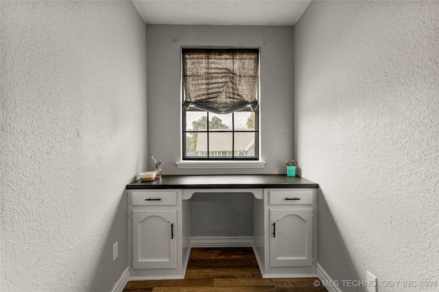 home office featuring built in desk and dark wood-type flooring