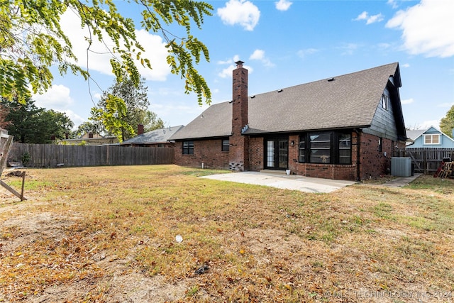 back of house featuring a lawn, a patio area, and central AC