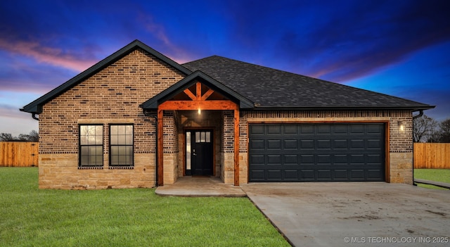 view of front of property with roof with shingles, concrete driveway, an attached garage, a front yard, and fence