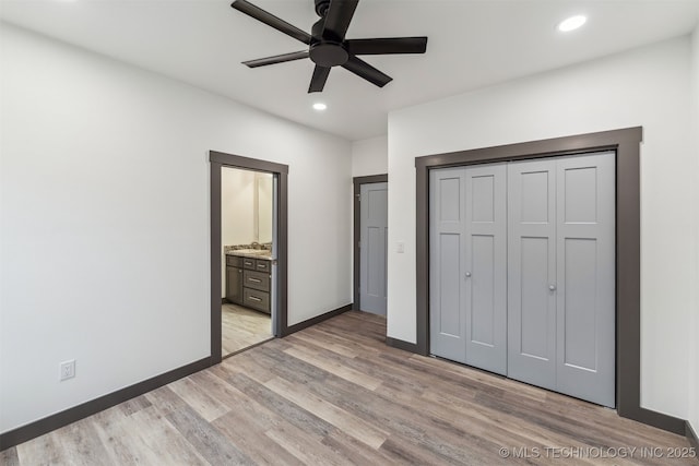 unfurnished bedroom with light wood finished floors, a closet, recessed lighting, and baseboards