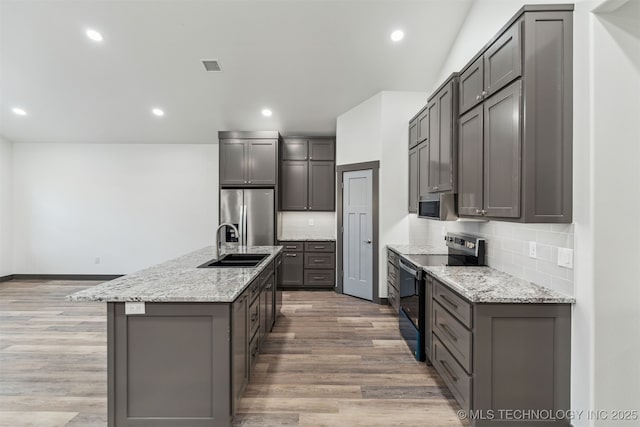 kitchen with appliances with stainless steel finishes, light wood-type flooring, visible vents, and gray cabinetry