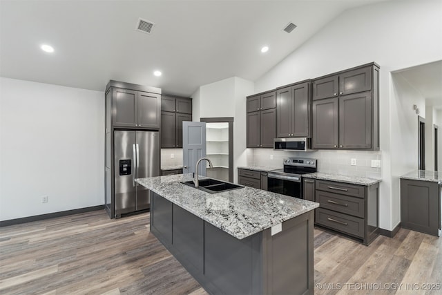 kitchen featuring tasteful backsplash, visible vents, lofted ceiling, stainless steel appliances, and a sink