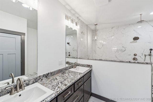 bathroom with double vanity, a shower, and a sink