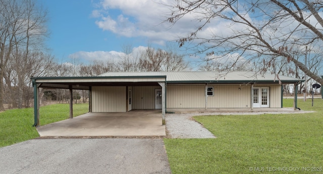 view of front of house with metal roof, driveway, french doors, a carport, and a front yard