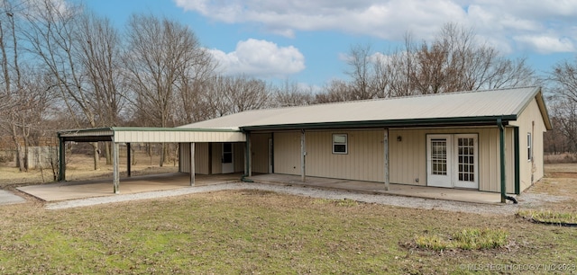 back of property with metal roof and a lawn