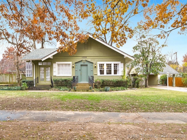 bungalow-style home featuring a carport and a front yard