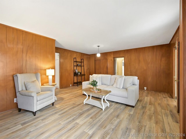 living room featuring wood walls and light wood-type flooring