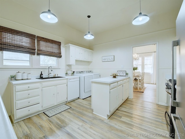 kitchen featuring light wood-type flooring, white dishwasher, sink, washer and dryer, and white cabinets