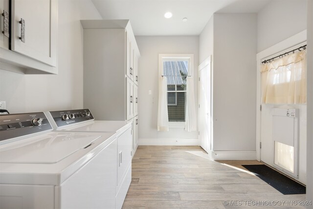 washroom with light hardwood / wood-style floors, cabinets, and independent washer and dryer