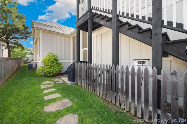 view of side of property featuring a yard and central AC unit