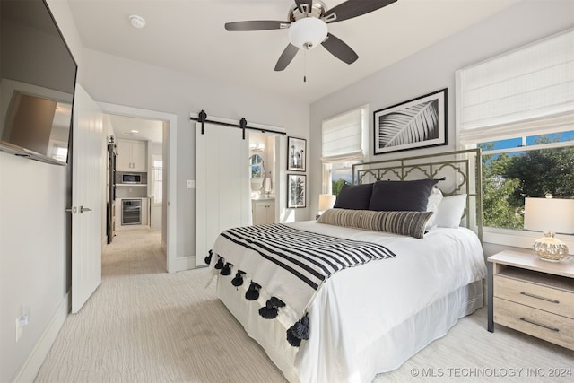 bedroom with a barn door, light colored carpet, ceiling fan, and beverage cooler