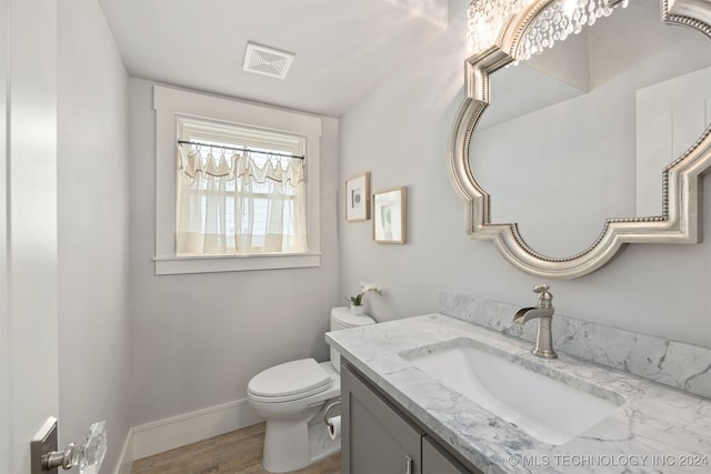 bathroom with hardwood / wood-style floors, vanity, and toilet