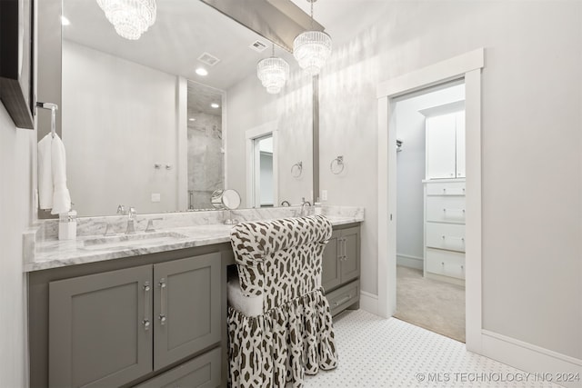 bathroom featuring a chandelier, a shower, and vanity