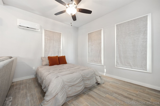 bedroom featuring wood-type flooring, a wall mounted AC, and ceiling fan