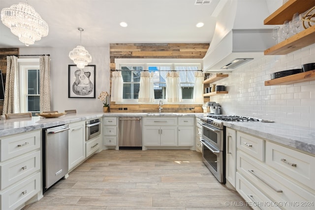 kitchen with hanging light fixtures, an inviting chandelier, light hardwood / wood-style flooring, white cabinets, and appliances with stainless steel finishes