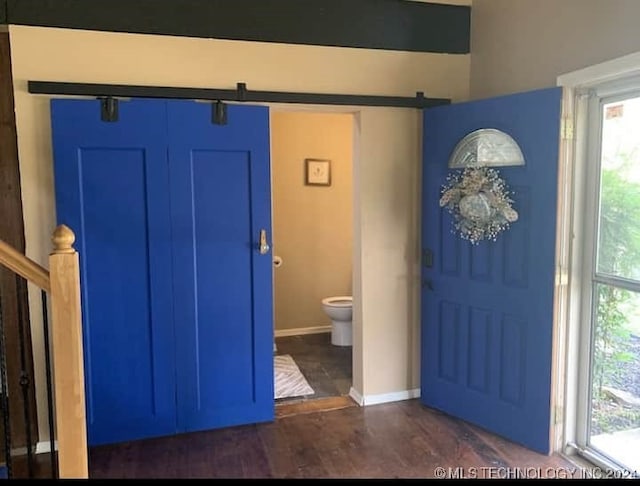 entrance foyer with dark hardwood / wood-style flooring and a barn door