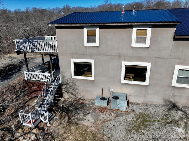 view of side of home with ac unit and a wooden deck