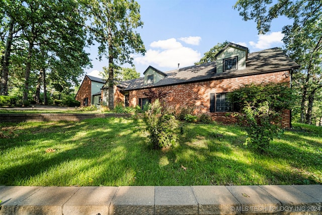 view of side of home with a yard