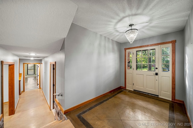 foyer with a textured ceiling and a notable chandelier