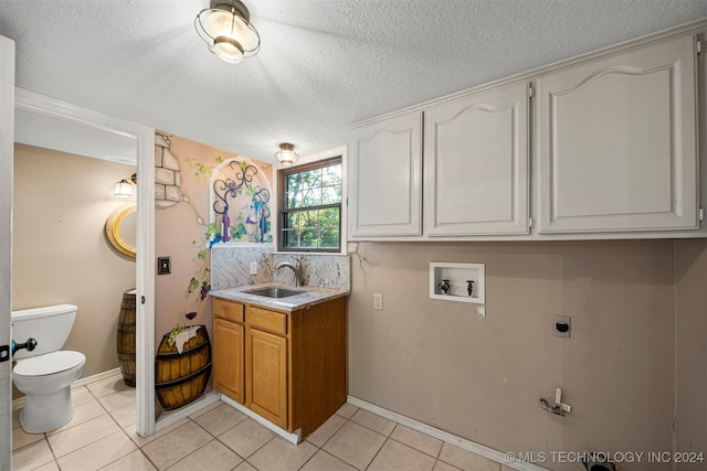 clothes washing area featuring electric dryer hookup, sink, washer hookup, and a textured ceiling