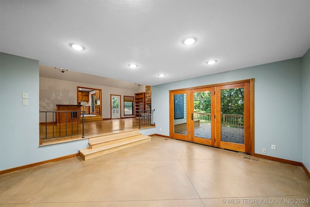 interior space featuring french doors and a textured ceiling