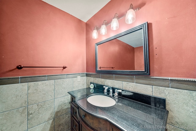 bathroom featuring vanity and tile walls