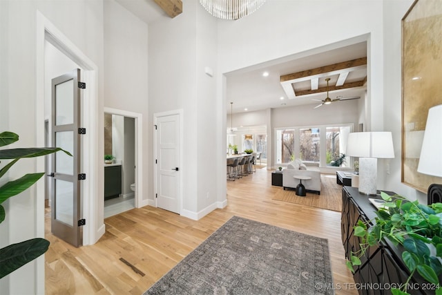 entryway featuring a high ceiling, ceiling fan, beam ceiling, and light hardwood / wood-style flooring