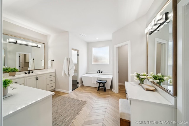 bathroom featuring vanity, parquet floors, and a washtub