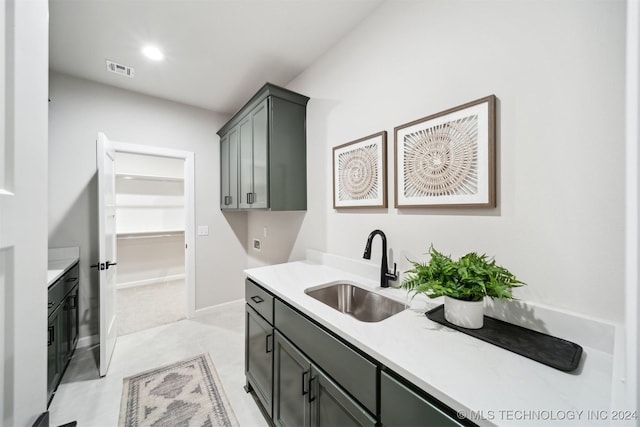 clothes washing area featuring sink and cabinets