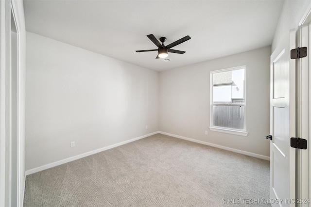 carpeted spare room featuring ceiling fan