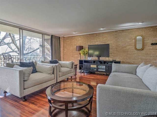 living room featuring crown molding, brick wall, and hardwood / wood-style flooring