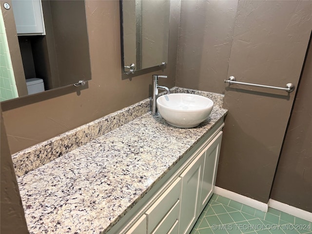 bathroom with tile patterned flooring, vanity, and toilet