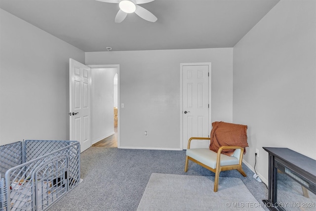 living area featuring carpet flooring and ceiling fan