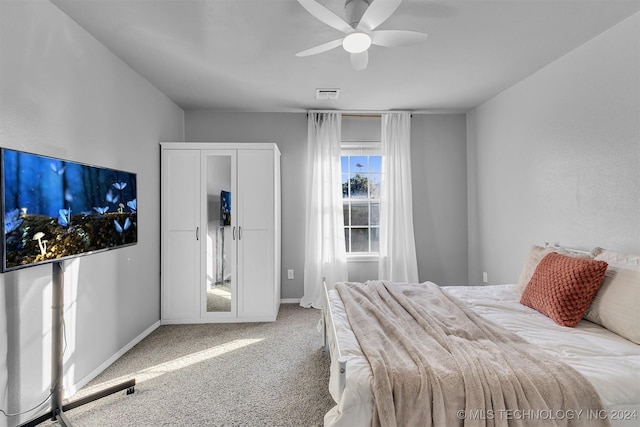 carpeted bedroom featuring ceiling fan and a closet