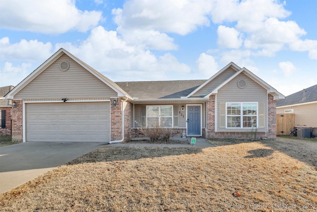 ranch-style house with a garage, a front yard, and central AC