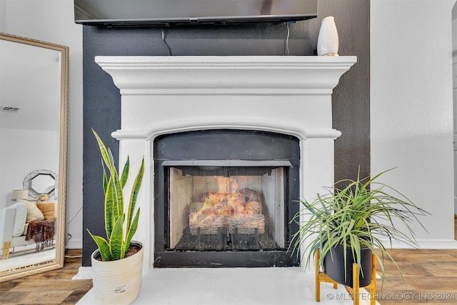 interior details with a multi sided fireplace and hardwood / wood-style flooring