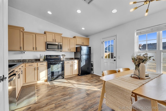 kitchen with light brown cabinets, a notable chandelier, lofted ceiling, black appliances, and light wood-type flooring