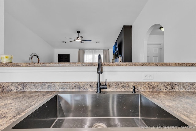 interior details featuring white cabinets, ceiling fan, and sink