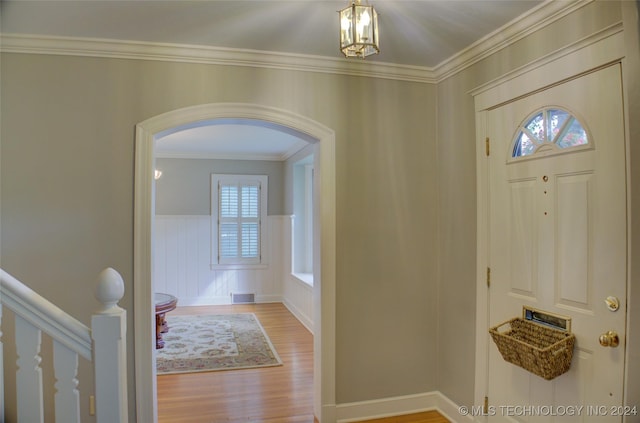 entryway featuring crown molding and light wood-type flooring