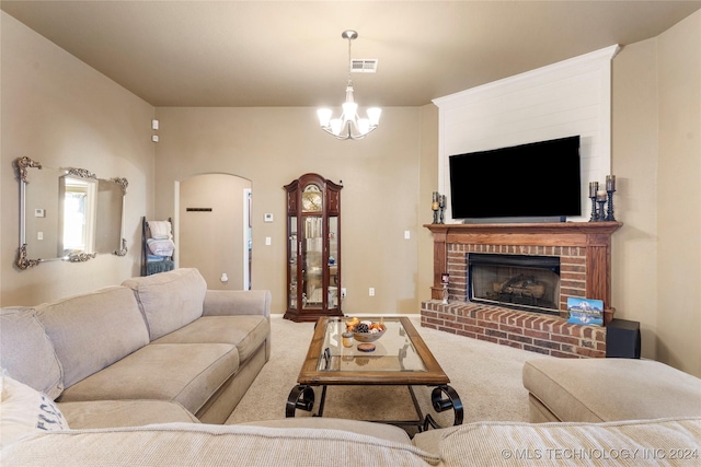 living room with a brick fireplace, carpet, and a notable chandelier