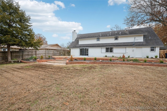 back of property featuring a yard