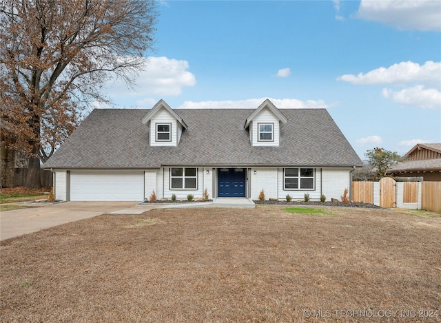 cape cod home with a front yard and a garage