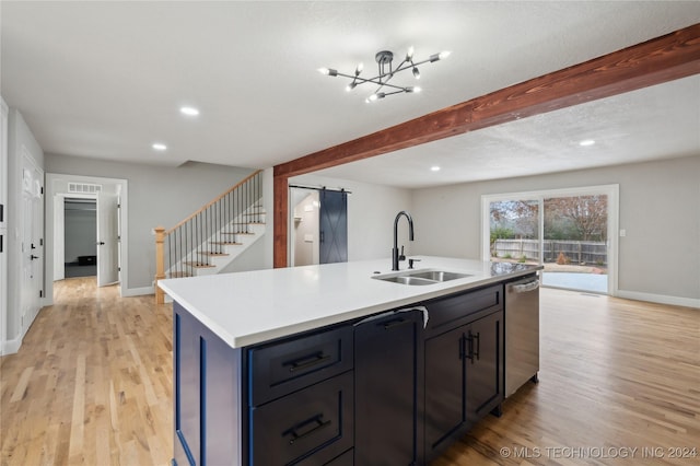 kitchen featuring sink, stainless steel dishwasher, an island with sink, light hardwood / wood-style floors, and a chandelier