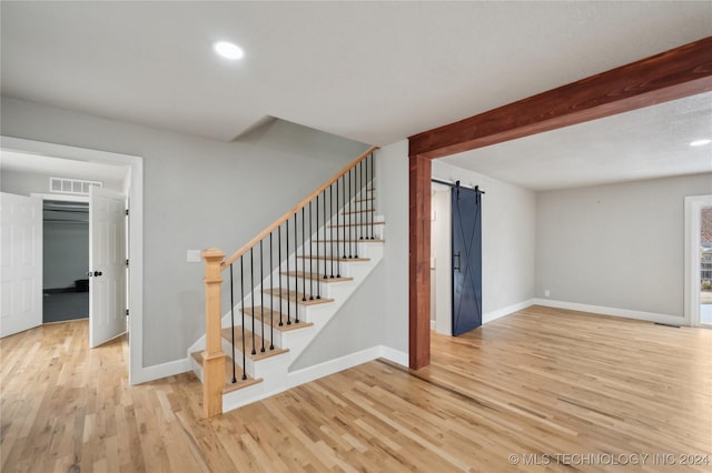 stairway with hardwood / wood-style floors and a barn door