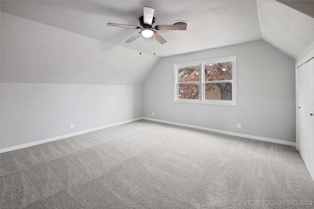 additional living space featuring ceiling fan, carpet, and vaulted ceiling