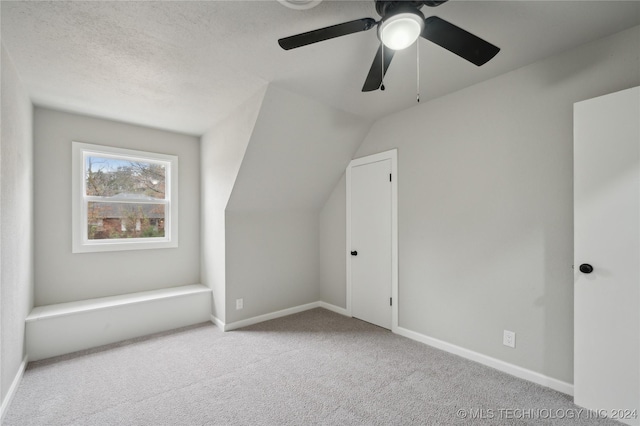 additional living space featuring ceiling fan, light carpet, and vaulted ceiling