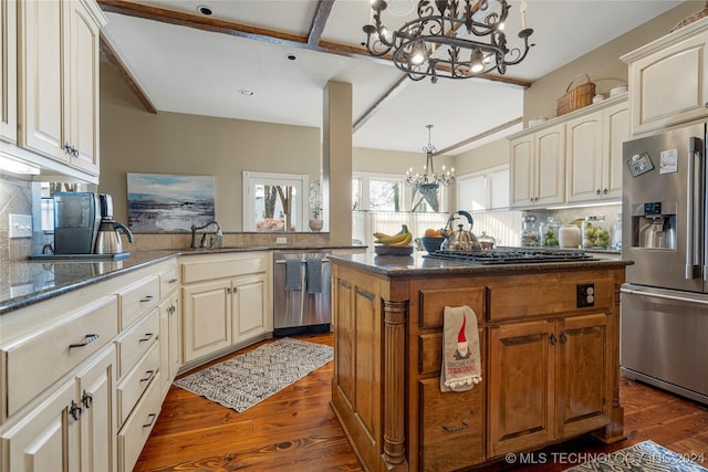 kitchen with hanging light fixtures, an inviting chandelier, dark hardwood / wood-style floors, kitchen peninsula, and appliances with stainless steel finishes