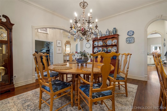 dining area with dark hardwood / wood-style flooring, an inviting chandelier, and ornamental molding