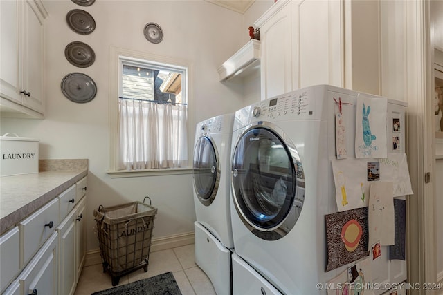 laundry area with cabinets, independent washer and dryer, and light tile patterned flooring