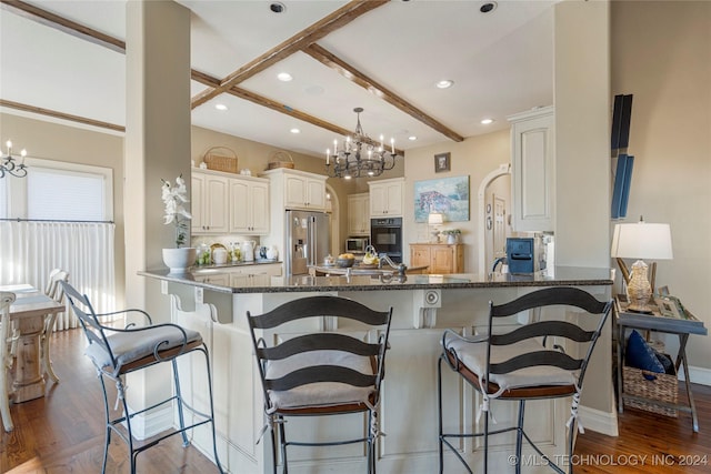 kitchen featuring kitchen peninsula, white cabinetry, high end fridge, and a breakfast bar